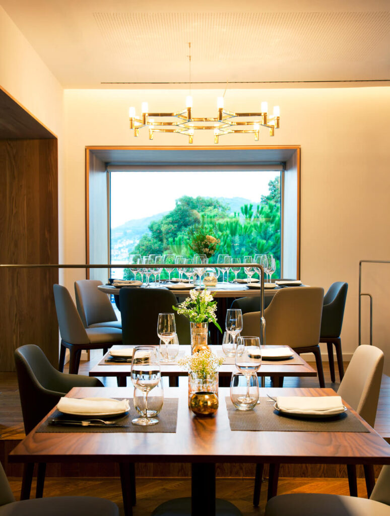 Comedor con el servicio puesto con amplia ventana al fondo